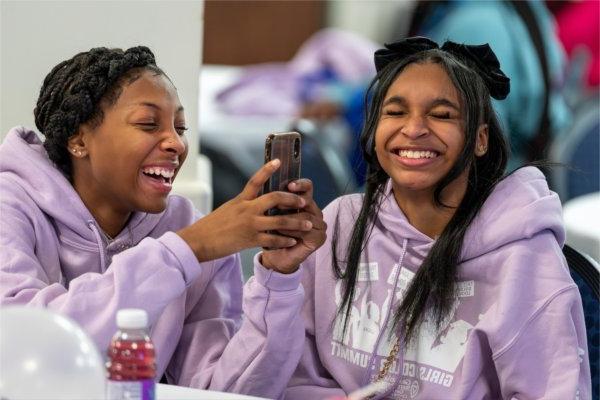 Godwin Heights students Aa'Nilah Miller, left, and Justice Lott laugh as they take photos